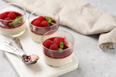 İtalyan sütlü panna cotta ahududu reçeli, taze ahududu ve mermer tahtada naneli