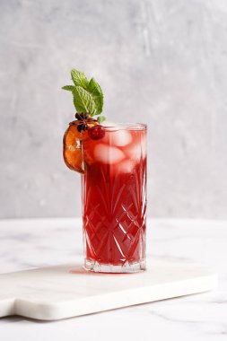 Geleneksel noel içeceği kırmızı kiraz suyu, portakal mandalinası, tarçın çubuğu, buz küpleri ve mermer tahtada anason soslu şarap.