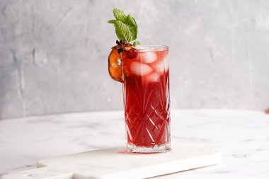 Geleneksel noel içeceği kırmızı kiraz suyu, portakal mandalinası, tarçın çubuğu, buz küpleri ve mermer tahtada anason soslu şarap.