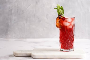 Geleneksel noel içeceği kırmızı kiraz suyu, portakal mandalinası, tarçın çubuğu, buz küpleri ve mermer tahtada anason soslu şarap.