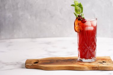 Geleneksel noel içeceği kırmızı kiraz suyu, portakal mandalinası, tarçın çubuğu, buz küpleri ve ahşap tahta üzerinde anason.