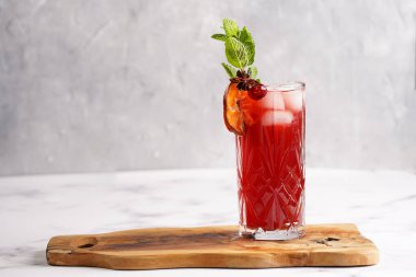 Geleneksel noel içeceği kırmızı kiraz suyu, portakal mandalinası, tarçın çubuğu, buz küpleri ve ahşap tahta üzerinde anason.