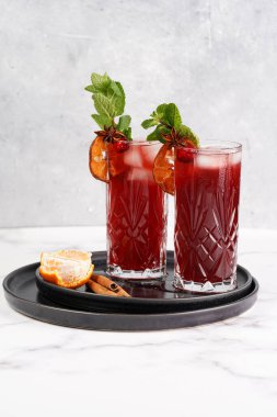 Geleneksel Noel içeceği kırmızı kiraz suyu, portakal mandalinası, tarçın çubuğu, buz küpleri ve siyah tepsilerde anason içeren sıcak şarap.