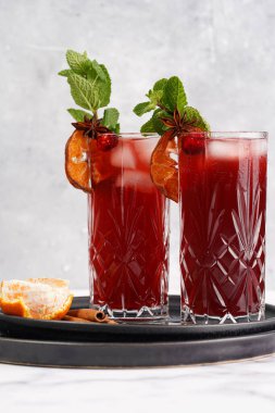 Geleneksel Noel içeceği kırmızı kiraz suyu, portakal mandalinası, tarçın çubuğu, buz küpleri ve siyah tepsilerde anason içeren sıcak şarap.