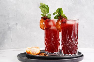 Geleneksel Noel içeceği kırmızı kiraz suyu, portakal mandalinası, tarçın çubuğu, buz küpleri ve siyah tepsilerde anason içeren sıcak şarap.