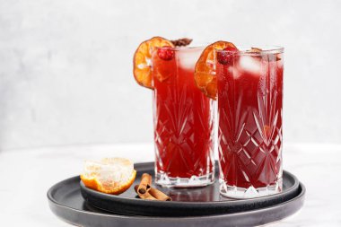 Geleneksel Noel içeceği kırmızı kiraz suyu, portakal mandalinası, tarçın çubuğu, buz küpleri ve siyah tepsilerde anason içeren sıcak şarap.