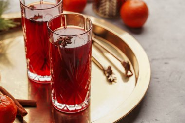 Geleneksel noel içeceği kırmızı kiraz suyu, portakal mandalinası, tarçın çubuğu ve altın tepside anason.