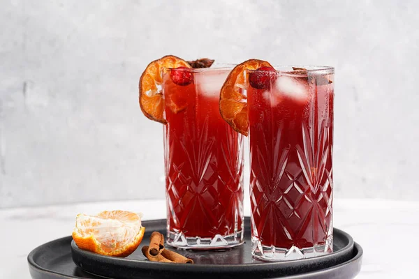 Geleneksel Noel içeceği kırmızı kiraz suyu, portakal mandalinası, tarçın çubuğu, buz küpleri ve siyah tepsilerde anason içeren sıcak şarap.