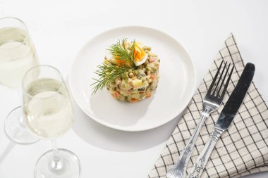 Yeni yıl arifesi için geleneksel Doğu Avrupa yemeği - patates, havuç, soğan, bezelye, sosis, salatalık, yumurta ve beyaz tabakta mayonez salatası 