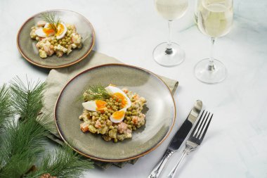 Yeni yıl arifesi için geleneksel Doğu Avrupa yemeği - patates, havuç, soğan, bezelye, sosis, sosis ve yeşil tabakta mayonez ile salata 