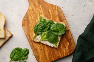 Tahtada krem peynirli ve ıspanaklı beyaz tost.