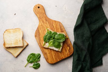 Tahtada krem peynirli ve ıspanaklı beyaz tost.