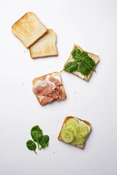 Toasts Blancs Fromage Crème Jambon Concombres Épinards Sur Une Surface — Photo