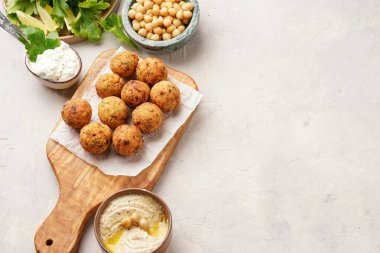Geleneksel oryantal nohut, ahşap bir tahtada kızartılmış falafel, tzatziki yoğurt sosu, humus, hafif yüzeyde taze limon ve yeşil kişniş, kopyalama alanı.