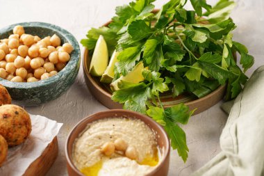 Geleneksel oryantal nohut, ahşap bir tahtada kızartılmış falafel, tzatziki yoğurt sosu, humus, taze limon ve yeşil kişniş.