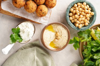 Geleneksel oryantal nohut, ahşap bir tahtada kızartılmış falafel, tzatziki yoğurt sosu, humus, taze limon ve yeşil kişniş.