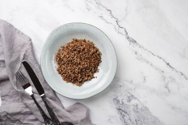 Geleneksel Doğu Avrupa karabuğdaylı gri seramik Scandi çorba kasesi mermer bir yüzey ve mutfak havlusu, üst görünüm, kopyalama alanı