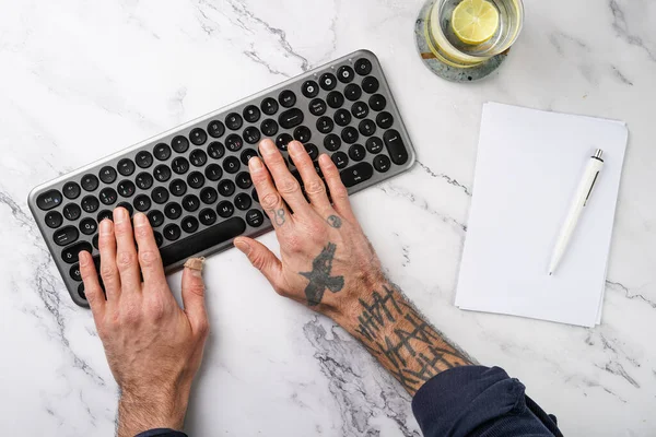 Mani Maschili Tatuate Che Lavorano Una Tastiera Senza Fili Vetro — Foto Stock