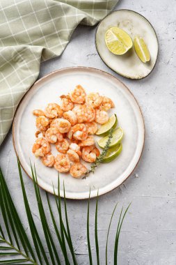 Limon, sarımsak ve taze otlarla servis edilen ızgara karides veya kaplan karidesleri. Beton yüzeyde Scandi yuvarlak tabağında. Peskataryan protein besin değeri