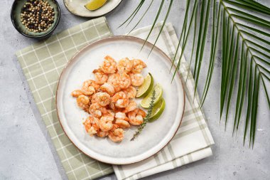 Limon, sarımsak ve taze otlarla servis edilen ızgara karides veya kaplan karidesleri. Beton yüzeyde Scandi yuvarlak tabağında. Peskataryan protein besin değeri