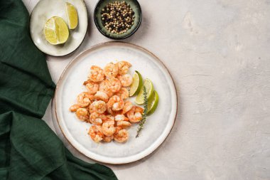 Limon, sarımsak ve taze otlarla servis edilen ızgara karides veya kaplan karidesleri. Beton yüzeyde Scandi yuvarlak tabağında. Peskataryan protein besin değeri
