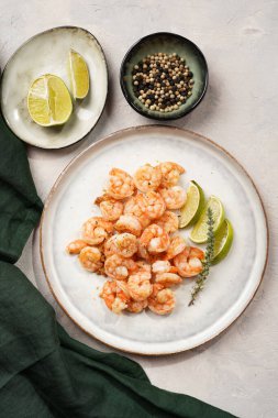 Limon, sarımsak ve taze otlarla servis edilen ızgara karides veya kaplan karidesleri. Beton yüzeyde Scandi yuvarlak tabağında. Peskataryan protein besin değeri