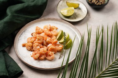 Limon, sarımsak ve taze otlarla servis edilen ızgara karides veya kaplan karidesleri. Beton yüzeyde Scandi yuvarlak tabağında. Peskataryan protein besin değeri