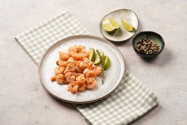 Limon, sarımsak ve taze otlarla servis edilen ızgara karides veya kaplan karidesleri. Beton yüzeyde Scandi yuvarlak tabağında. Peskataryan protein besin değeri