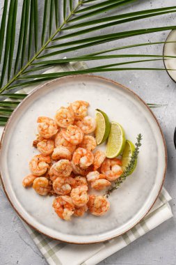 Limon, sarımsak ve taze otlarla servis edilen ızgara karides veya kaplan karidesleri. Beton yüzeyde Scandi yuvarlak tabağında. Peskataryan protein besin değeri