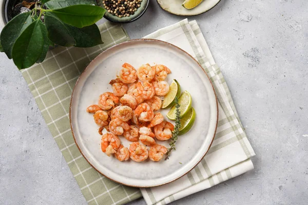 Limon, sarımsak ve taze otlarla servis edilen ızgara karides veya kaplan karidesleri. Beton yüzeyde Scandi yuvarlak tabağında. Peskataryan protein besin değeri