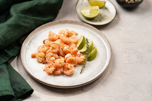 Limon, sarımsak ve taze otlarla servis edilen ızgara karides veya kaplan karidesleri. Beton yüzeyde Scandi yuvarlak tabağında. Peskataryan protein besin değeri