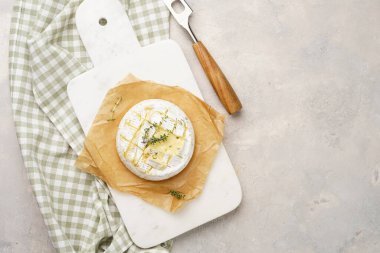 Fırında peynirli camembert peyniri, mermer tahtada sodyum somon ekmeği, gri beton yüzey. Ev yapımı kekik soslu krem peynir.