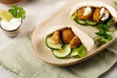 Geleneksel oryantal nohut köftesi pide, tzatziki yoğurt sosu, humus, taze kireç ve yeşil kişniş.