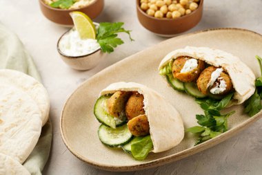 Geleneksel oryantal nohut köftesi pide, tzatziki yoğurt sosu, humus, taze kireç ve yeşil kişniş.