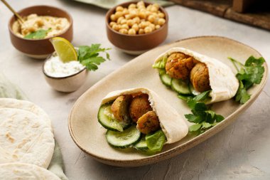 Geleneksel oryantal nohut köftesi pide, tzatziki yoğurt sosu, humus, taze kireç ve yeşil kişniş.