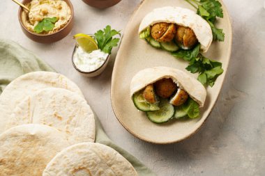 Geleneksel oryantal nohut köftesi pide, tzatziki yoğurt sosu, humus, taze kireç ve yeşil kişniş.