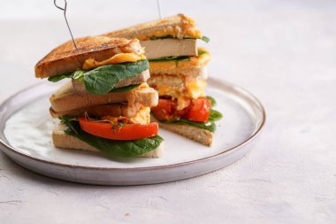 Amerikan yapımı, tofu, çedar peynirli, domates dilimli ve üçgen şeklinde kesilmiş beyaz tarama tabağında ıspanaklı ev yapımı peynirli sandviç. İtalyan Tramezzini