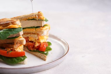 Amerikan yapımı, tofu, çedar peynirli, domates dilimli ve üçgen şeklinde kesilmiş beyaz tarama tabağında ıspanaklı ev yapımı peynirli sandviç. İtalyan Tramezzini