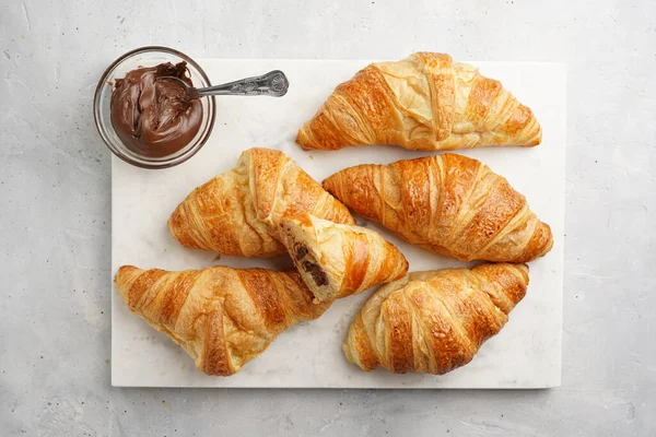 Fındık ezmeli mermer tepside yeni pişmiş Fransız kruvasanı.