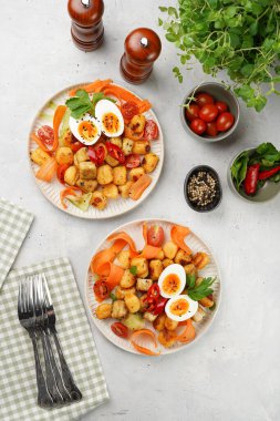 Tatlı patates gnocchi ve teriyaki tofu ile Endonezya sebze salatası gado - havuç, salatalık, domates, kişniş, susam tohumu, haşlanmış yumurta ve fıstık ezmesi sosu beyaz tabakta.