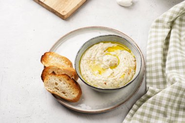 Geleneksel Arap mutfağı, patlıcan, tahin, kişniş, sarımsak, zeytin yağı, kızarmış baget ekmekli limon suyu ve gri arka planda kızarmış ekmek.