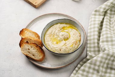 Geleneksel Arap mutfağı, patlıcan, tahin, kişniş, sarımsak, zeytin yağı, kızarmış baget ekmekli limon suyu ve gri arka planda kızarmış ekmek.