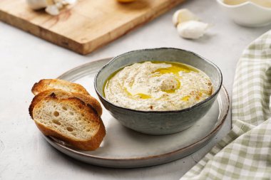 Geleneksel Arap mutfağı, patlıcan, tahin, kişniş, sarımsak, zeytin yağı, kızarmış baget ekmekli limon suyu ve gri arka planda kızarmış ekmek.