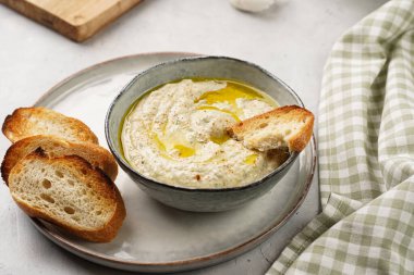 Geleneksel Arap mutfağı, patlıcan, tahin, kişniş, sarımsak, zeytin yağı, kızarmış baget ekmekli limon suyu ve gri arka planda kızarmış ekmek.