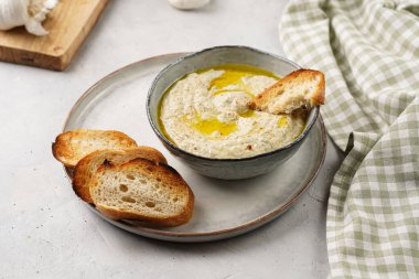 Geleneksel Arap mutfağı, patlıcan, tahin, kişniş, sarımsak, zeytin yağı, kızarmış baget ekmekli limon suyu ve gri arka planda kızarmış ekmek.