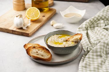 Geleneksel Arap mutfağı, patlıcan, tahin, kişniş, sarımsak, zeytin yağı, kızarmış baget ekmekli limon suyu ve gri arka planda kızarmış ekmek.