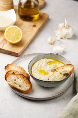 Geleneksel Arap mutfağı, patlıcan, tahin, kişniş, sarımsak, zeytin yağı, kızarmış baget ekmekli limon suyu ve gri arka planda kızarmış ekmek.