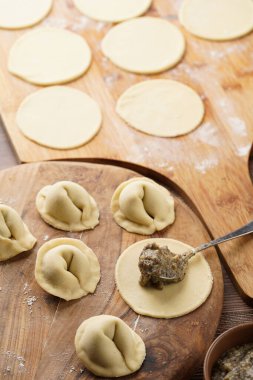 Geleneksel Ukrayna usulü Avrupa yemekleri hazırlama süreci. Patates-mantar ezmesiyle doldurulmuş hamur tatlısı. Ahşap arkaplan