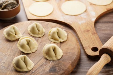 Geleneksel Ukrayna usulü Avrupa yemekleri hazırlama süreci. Patates-mantar ezmesiyle doldurulmuş hamur tatlısı. Ahşap arkaplan