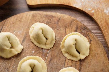 Geleneksel Ukrayna usulü Avrupa yemekleri hazırlama süreci. Patates-mantar ezmesiyle doldurulmuş hamur tatlısı. Ahşap arkaplan
